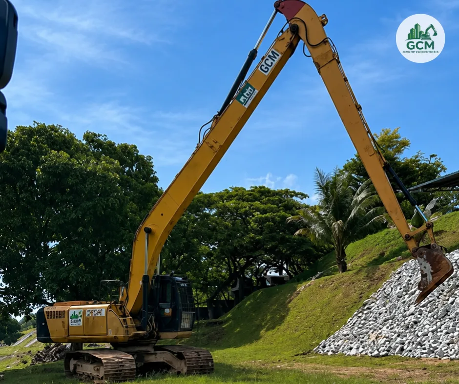 Long arm excavator trimming a high slope beside a main road in Johor Bahru
