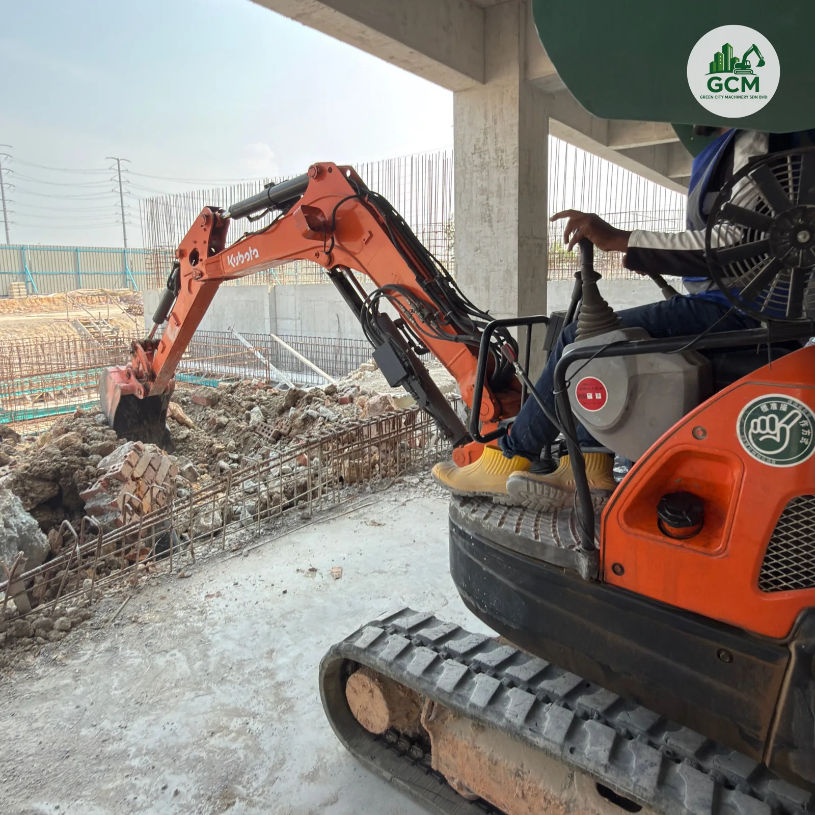 3-tonne mini excavator digging an internal pipeline trench under a concrete deck on a Johor construction site